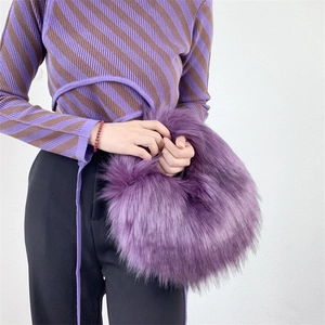 Detail of purple faux raccoon fur handbag showing the fluffy long plush texture and soft handle