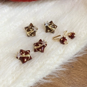 Detailed macro of star-shaped 18k gold earrings with cat pattern and zircon inlay