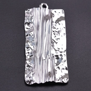 Macro shot of silver rectangle pendant with hammered texture and ridged 304 stainless steel