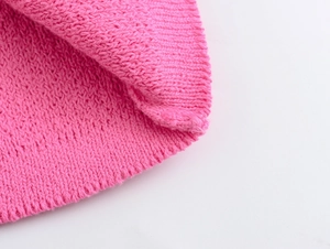 Detailed macro view of pink knit cardigan texture and high-quality stitching detail