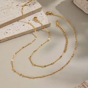Minimalist 18K gold plated stainless steel bone link necklace on natural stone backdrop