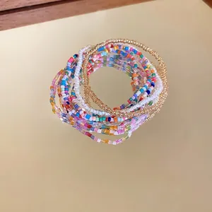 Bohemian colorful seed bead bracelet set of seven pieces stacked on gold mirror