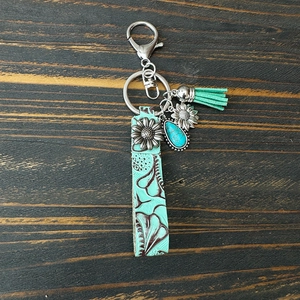 Détail d'un porte-clés en cuir vintage avec pierres turquoises et charm tournesol