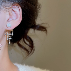 Macro shot of 14K gold plated tassel earrings with pearls and marquise cut zircons