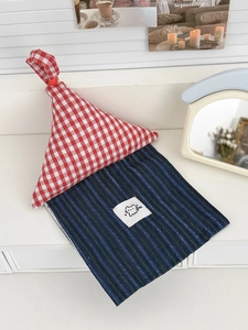 Close-up of a house-shaped tissue holder with red gingham top and navy striped body