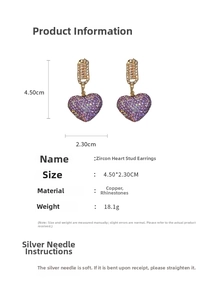 Macro view of gold plated heart earrings featuring purple cubic zirconia and crystal details