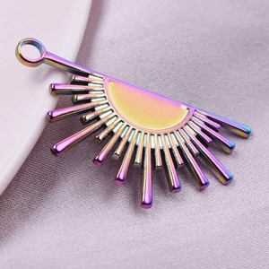 Macro shot of 18k vacuum plated rainbow sunflower charm on soft pink fabric detail