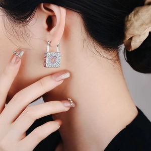Elegant lock earrings with white zircon and pink heart charm shown on model