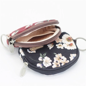 Detail of floral canvas coin purse featuring interior pocket and metal keyring attachment