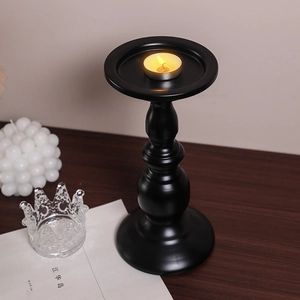 European matte black iron candle holder on dark wood table for home decor