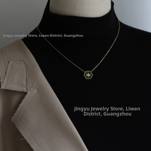 Detail of a vintage bee hexagon pendant necklace on a model wearing a beige blazer