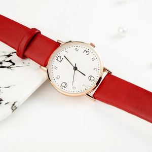 Detail of red leather strap and gold watch case with white dial and numeric scale