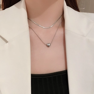Close-up of double-layer silver heart necklace set on neck with minimalist styling
