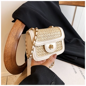 Detail of mini straw bag with contrast PU leather trim and metal flower clasp