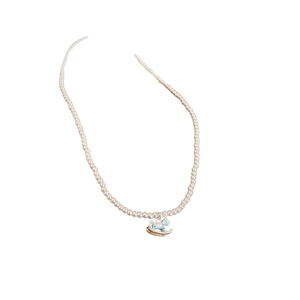 Elegant pearl necklace featuring a colorful enamel rocking horse pendant on a white background