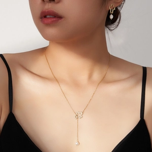 Détail du collier croix évidée en argent S925 et boucles d'oreilles en perles
