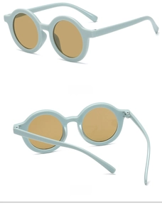 Detail view of round frame kids sunglasses in mint green with amber lenses