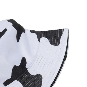 Close-up of black and white cow print canvas fabric with detailed multi-row brim stitching