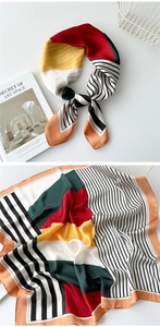 Detail view of geometric silk scarf with bold red and yellow patterns and refined rolled edges