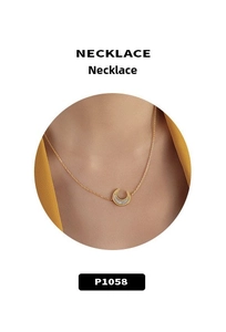 Dettaglio di una collana in oro 18k con pendente a luna e intarsio in madreperla