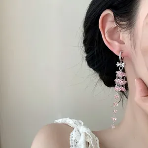 Vue détaillée des boucles d'oreilles à franges en cristal rose avec nœud étincelant
