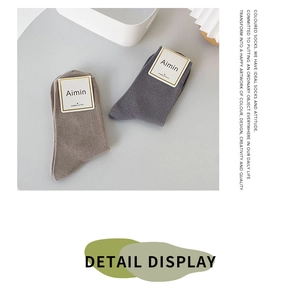 Close-up of combed cotton socks in brown and grey with minimalist brand tag detail