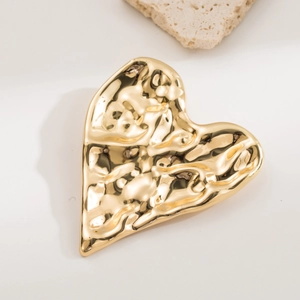 Golden heart-shaped metal jewelry tray with a unique hammered texture and glossy finish