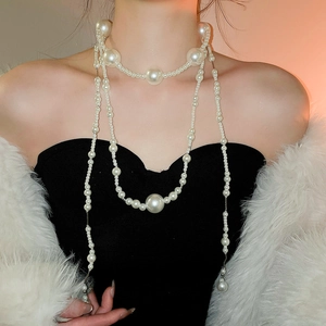 Detail of elegant multi-layer pearl necklace with graduated beads on black dress