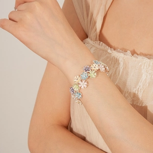 Close-up of a model wearing the colorful enamel flower bracelet on her wrist