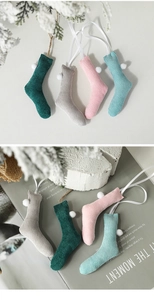 Mini knitted Christmas stockings in green, pink, grey and blue with white pom-poms