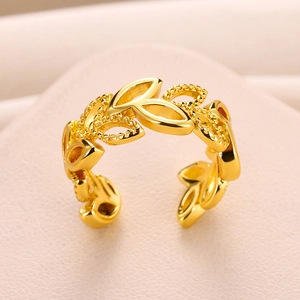 Macro detail of gold adjustable ring featuring olive leaf branch minimalist design
