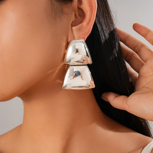Close-up of geometric trapezoid silver earrings with a high-polished mirror finish on model