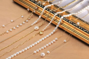 Detailed view of elegant S925 silver pearl necklaces on a vintage gold frame display