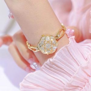 Elegant gold camellia bracelet watch with crystals on a wrist for a luxury women's look