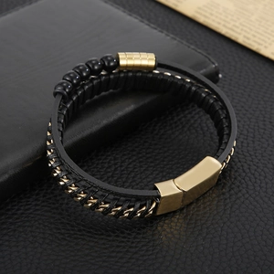 Detail of men's multilayered black leather bracelet with gold chain and magnetic clasp