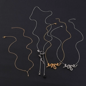 Flat lay of punk style gold and silver snake necklaces with black bead accent details