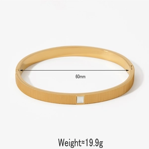 Detail of gold metal bangle with vertical textures and white inlay, inner diameter 60mm