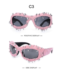 Detail view of pink punk sunglasses with silver metal studs and spikes on textured frames