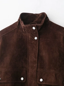 Detailed close-up of dark brown suede jacket collar with silver metal buttons