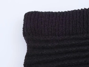 Dettaglio del tessuto a maglia nera che mostra la trama a costine e il materiale