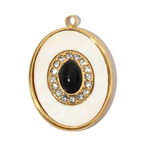 Close-up of vintage oval gold-plated pendant with black natural stone and crystals