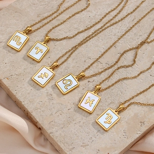 Detail of 6 gold constellation necklaces with white shell rectangular pendants on silk