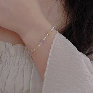 Close-up of a beaded heart pearl bracelet with colorful natural stones on a wrist