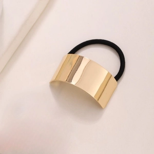 Detail of a minimalist gold brushed metal buckle attached to a black high-elastic hair tie