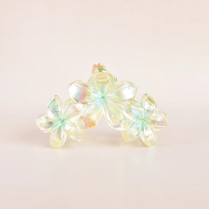 Detail of floral hair claw clip with transparent iridescent finish and three-flower design