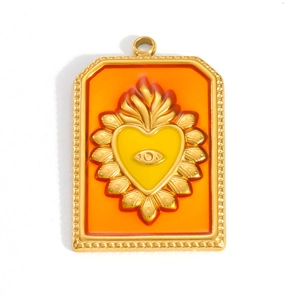 Detailed view of an 18k gold plated sacred heart pendant with orange enamel and eye symbol