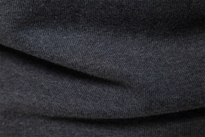Detailed close-up of dark grey knitted fabric showing thick premium texture and weave