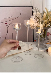 Three-piece long stem clear glass candle holders set with tea lights in a modern decor