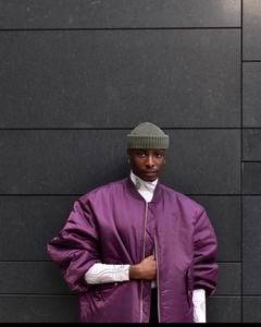 Detail view of purple satin oversized bomber jacket with smooth glossy fabric texture