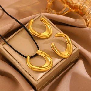 Detailed view of golden teardrop jewelry set on luxury silk background with elegant lighting
